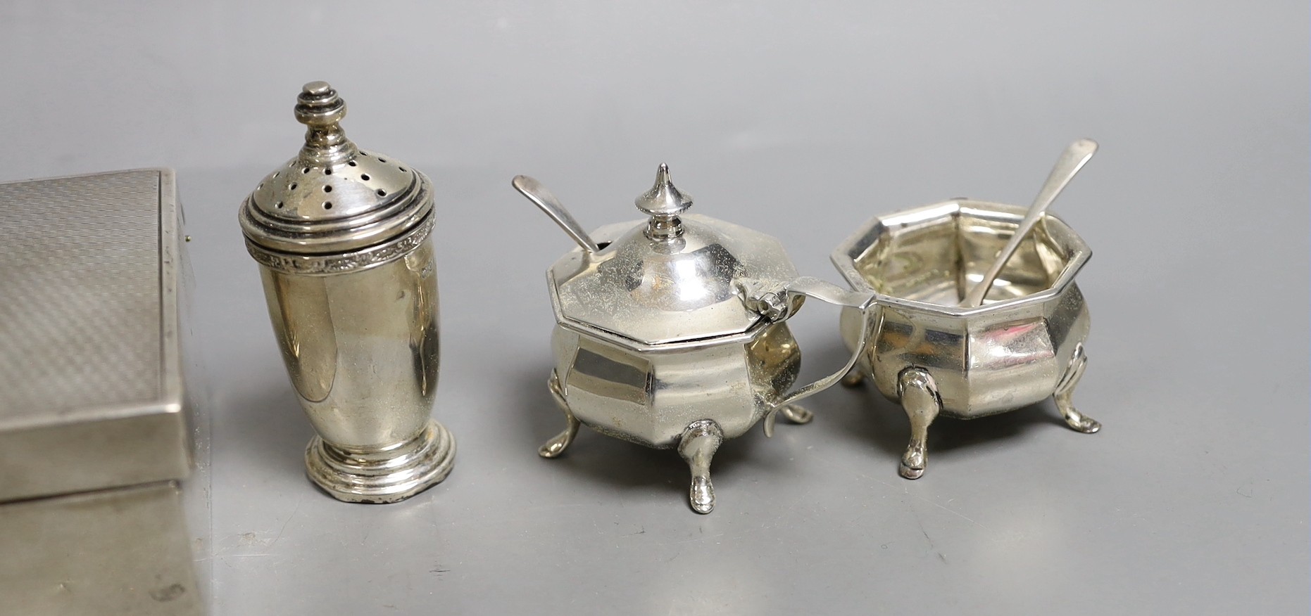 Six assorted silver condiments and a silver mounted cigarette box.